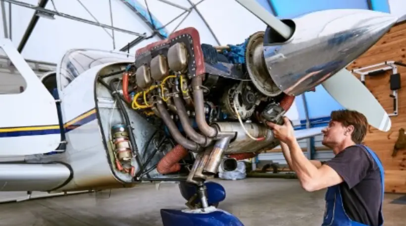 Mechanic examining airplane exhaust